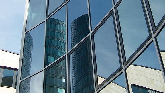 Titel der Produktbroschüre BauStatik - Glasbau. Zu sehen ist eine Glasfassade.