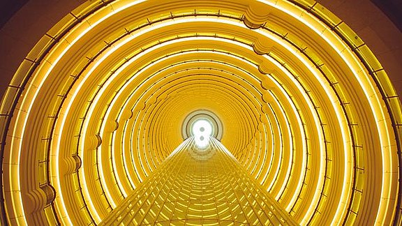 Versionslogo mb WorkSuite 2018 - abstrakter Bildausschnitt des runden Atriums des Grand Hyatt in Shanghai in der vorherrschenden Farbe Gelb.