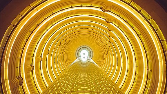 Versionslogo mb WorkSuite 2018 - abstrakter Bildausschnitt des runden Atriums des Grand Hyatt in Shanghai in der vorherrschenden Farbe Gelb.  