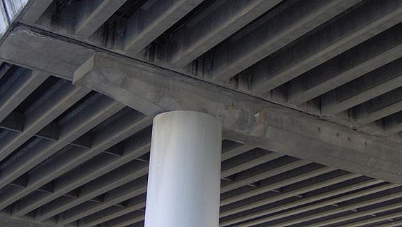 Titel der Produktbroschüre MicroFe - Brückenbau. Zu sehen ist ein Brückenpfeiler einer Stahlbetonbrücke.