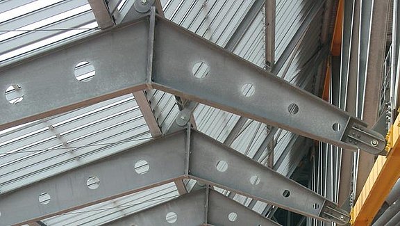 Titel der Produktbroschüre BauStatik - Stahlbau. Zu sehen ist sind mehrere Stahlträger einer Stadionüberdachung. 