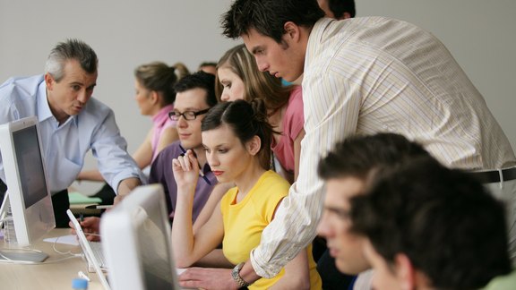 Mehrere Studenten helfen sich gegenseitig am Computer